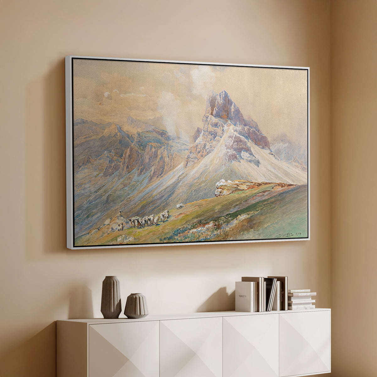 White floater framed canvas of From the Dolomites, 1904 by Edward Theodore Compton, featuring an alpine scene with jagged rock formations and distant mountains above a console cabinet in a minimalist entryway.