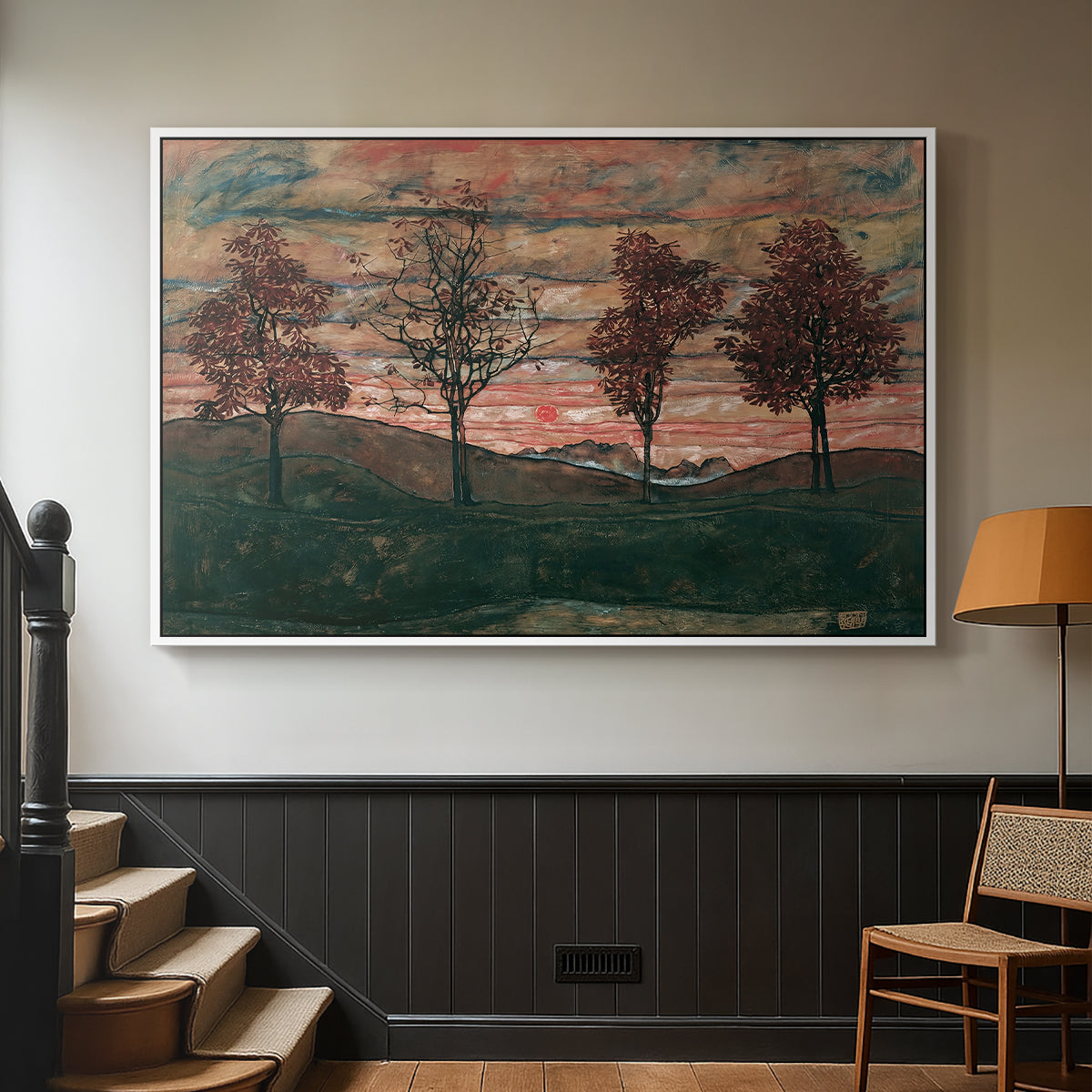 White floater framed canvas featuring an expressionist landscape featuring isolated trees in field, displayed in a hallway near a staircase.