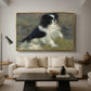 Tama, the Japanese Dog, c. 1876 by Pierre-Auguste Renoir as a gold floater framed canvas featuring a small black and white dog standing in shallow water with soft brushstrokes, displayed above a sofa in a modern living room.