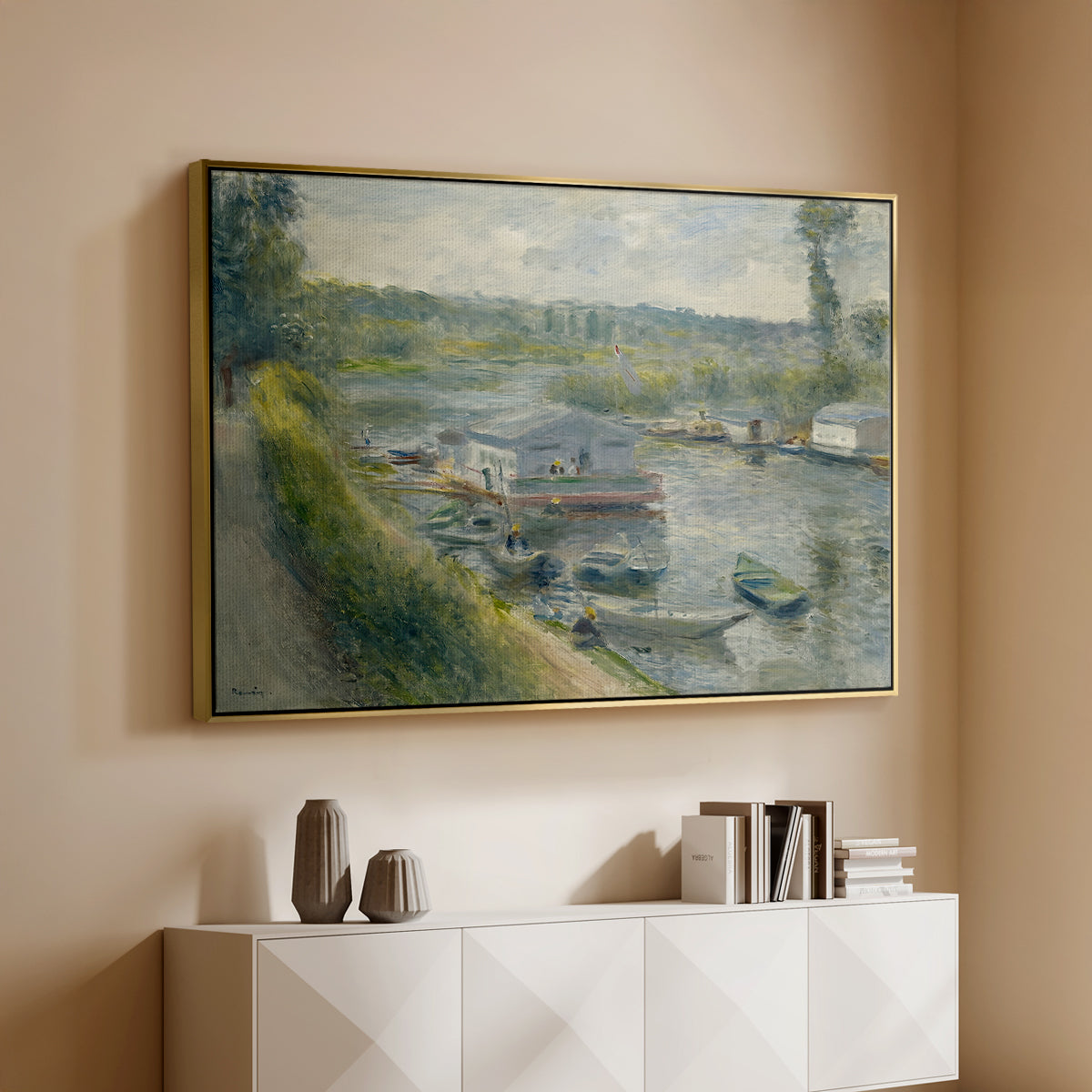 Gold floater framed canvas of Wash-House Boat at Bas-Meudon, c. 1874 by Pierre-Auguste Renoir, featuring a riverside scene with moored boat used for washing clothes above a console cabinet in a minimalist entryway.