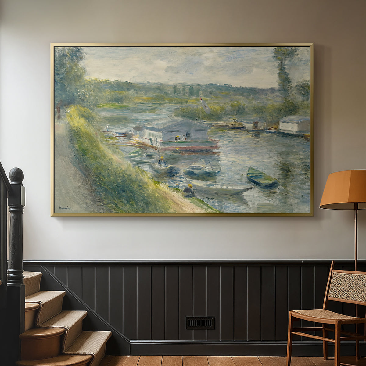 Gold floater framed canvas featuring an everyday life scene with boat and figures along river edge, displayed in a hallway near a staircase.