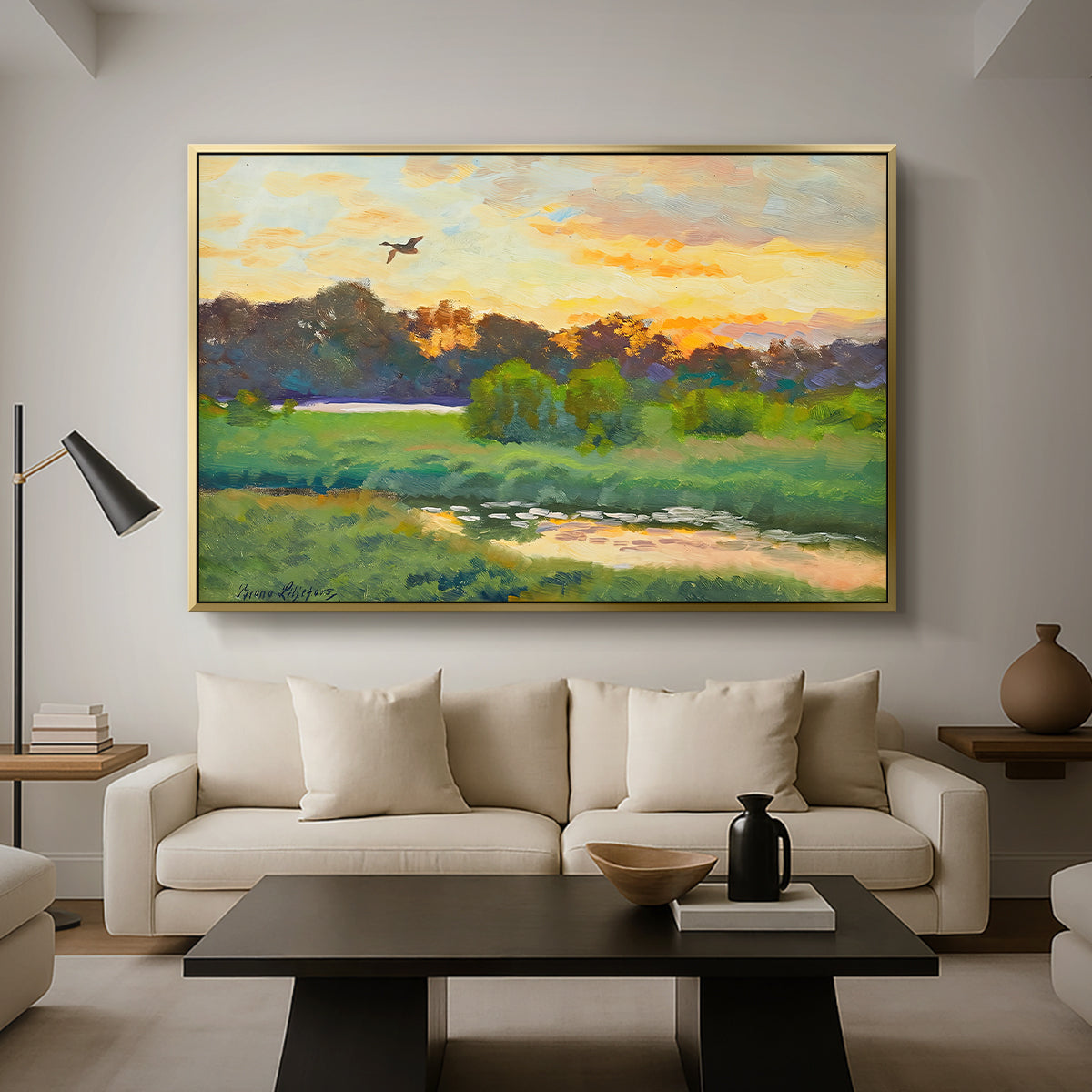 Flying Duck at Sunset, 1924 by Bruno Liljefors as a gold floater framed canvas featuring a wild duck flying over a sunset marsh with trees, displayed above a sofa in a modern living room.