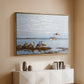 Gold floater framed canvas of Greylag Geese (Grågäss), 1922 by Bruno Liljefors, featuring birds standing and resting along shoreline with soft grass and water above a console cabinet in a minimalist entryway.