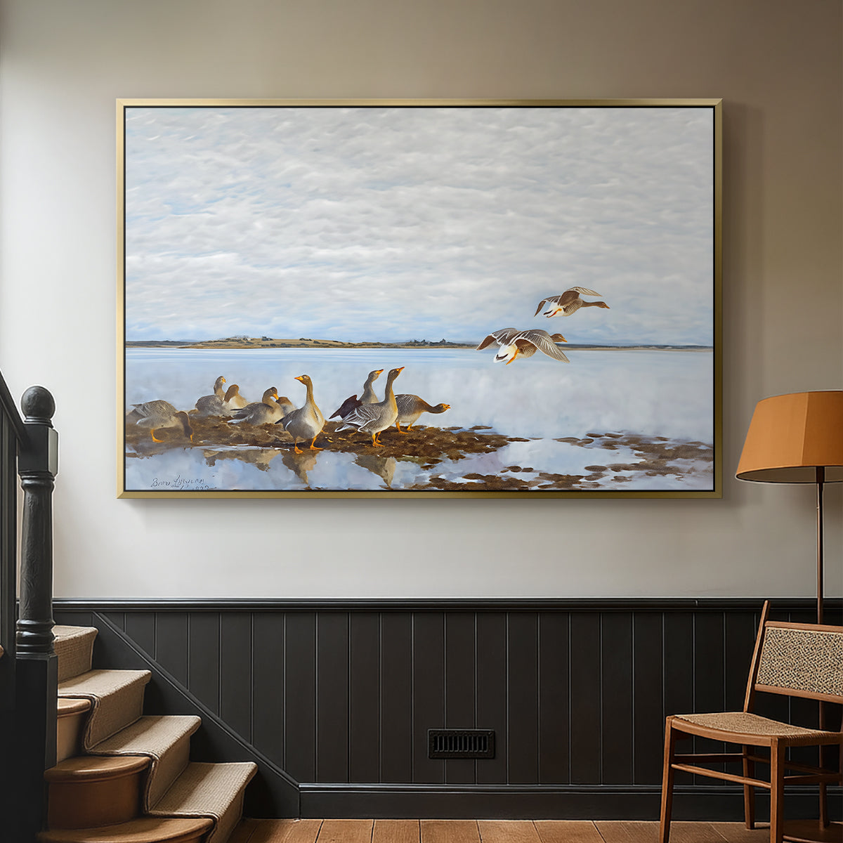 Gold floater framed canvas featuring a flock of geese positioned along marshy terrain, displayed in a hallway near a staircase.