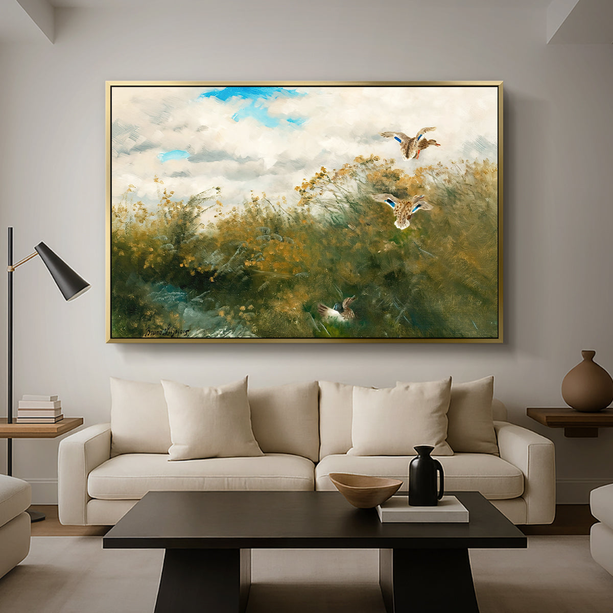 Wild Ducks (Grasänder), 1890 by Bruno Liljefors as a gold floater framed canvas featuring ducks moving through grassy wetland near water's edge, displayed above a sofa in a modern living room.