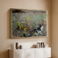 Gold floater framed canvas of Cat on a Flowery Meadow, 1887 by Bruno Liljefors, featuring a small cat resting among colorful flowers in grassy field above a console cabinet in a minimalist entryway.