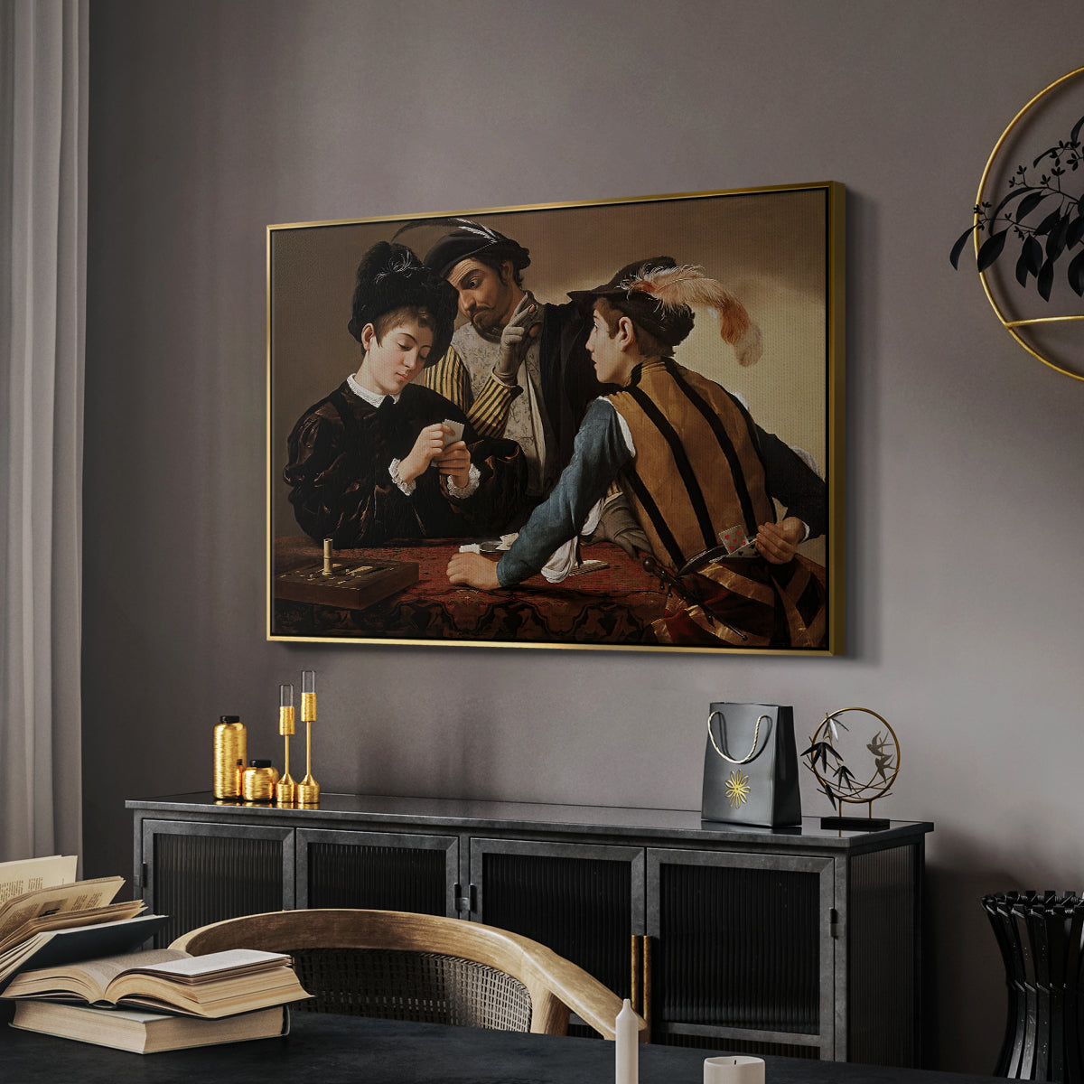 The Cardsharps, c. 1594 by Caravaggio in a gold floater framed canvas featuring a young men playing cards with one cheating and another watching closely, displayed above a desk in a dark home office interior.