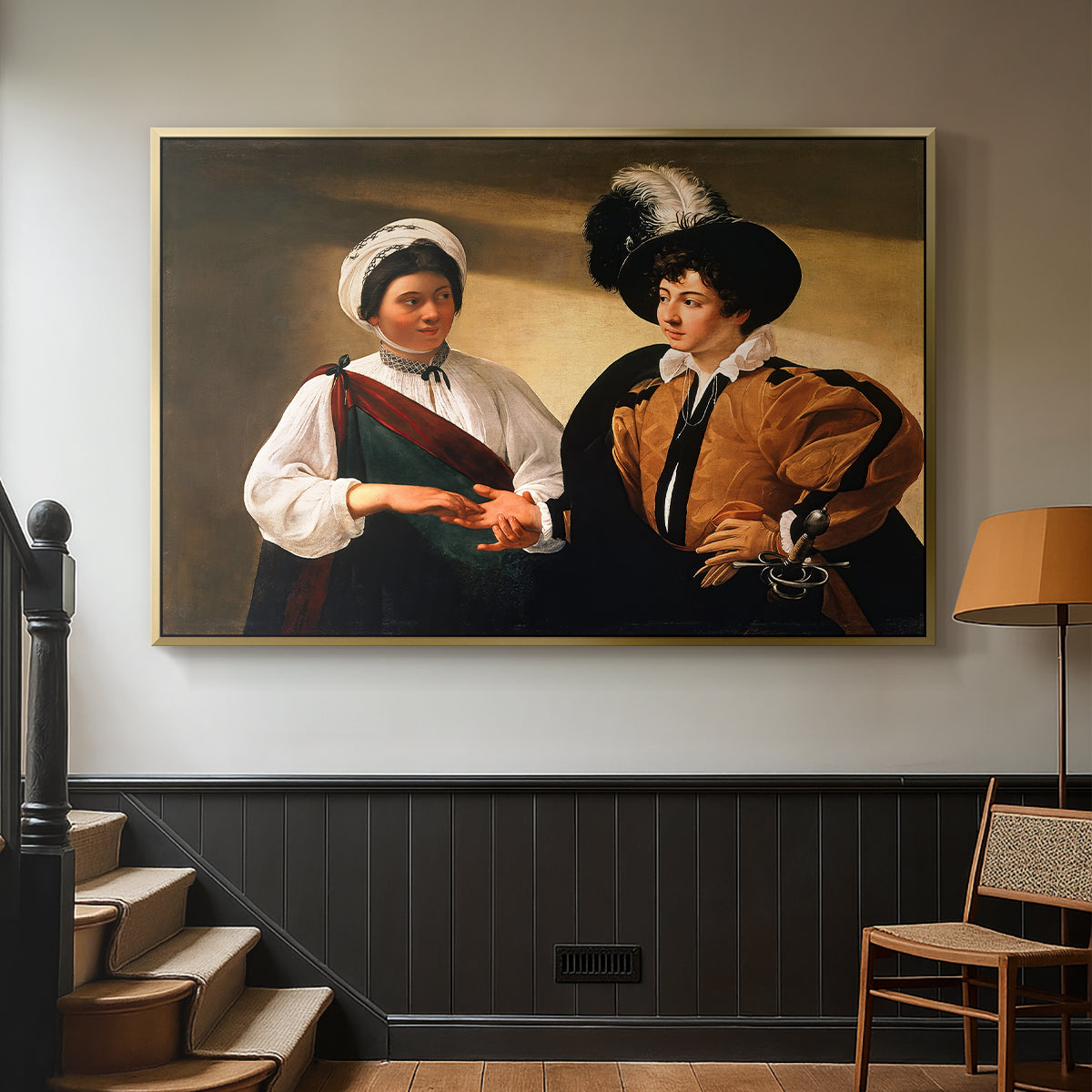 Gold floater framed canvas featuring two figures engaged in fortune telling with hidden deception, displayed in a hallway near a staircase.