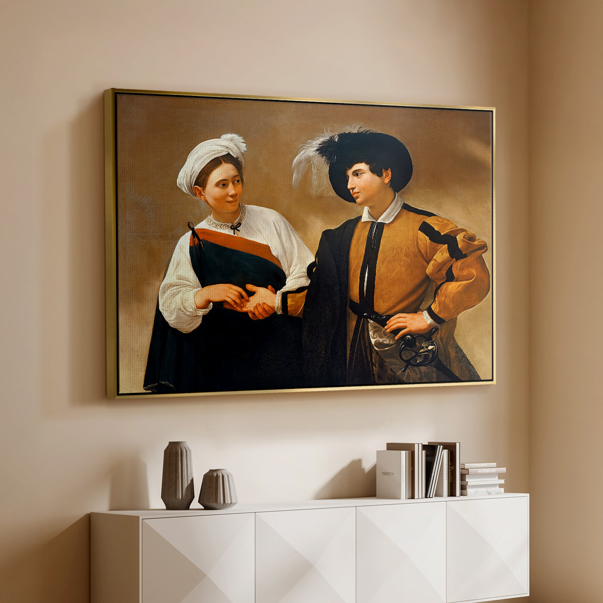 Gold floater framed canvas of The Fortune Teller (Capitoline Version), c. 1599 by Caravaggio, featuring a fortune teller tricking young man during palm reading above a console cabinet in a minimalist entryway.