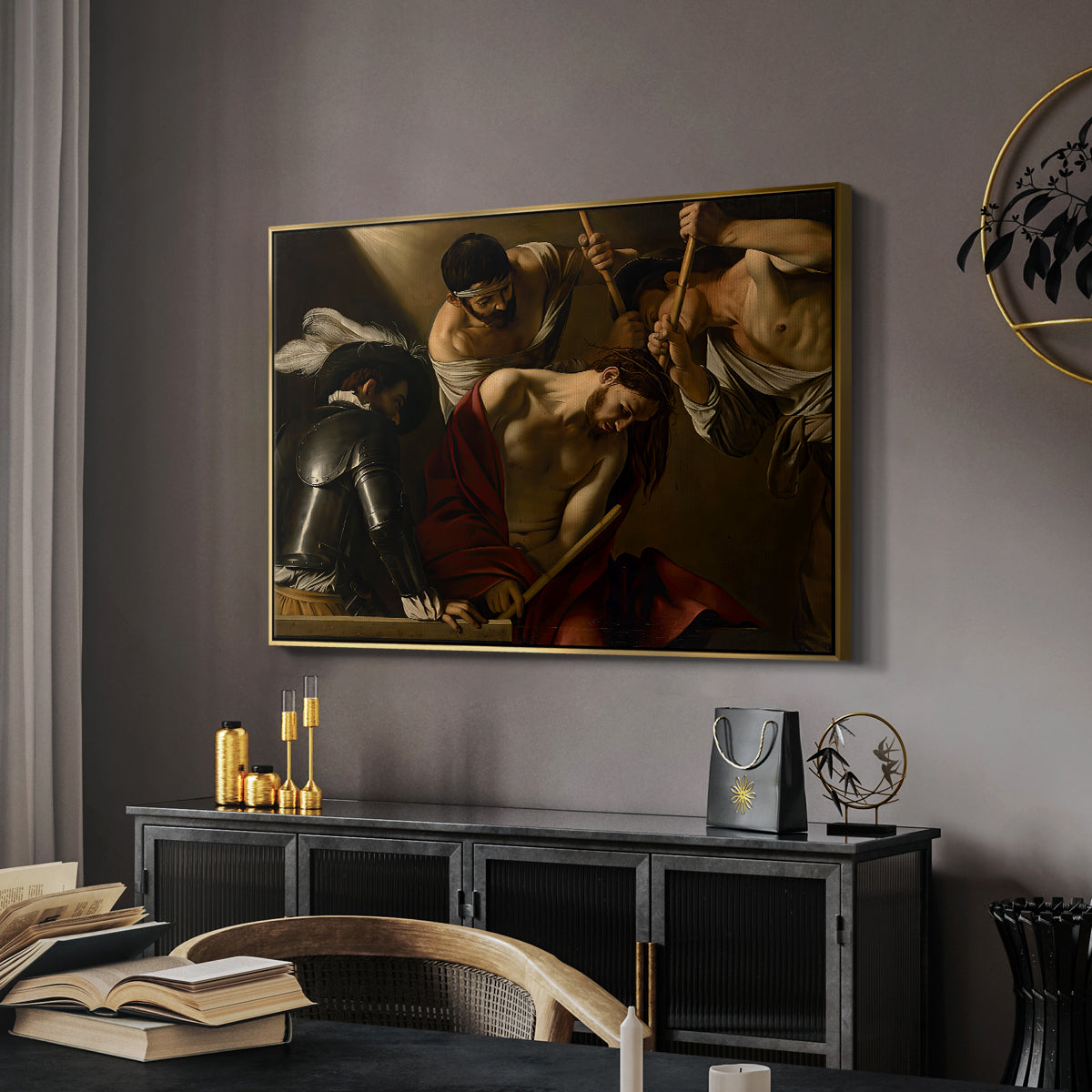 The Crowning with Thorns (Vienna Version), c. 1602-1604 by Caravaggio in a gold floater framed canvas featuring a dramatic depiction of figures forcing thorn crown onto Christ, displayed above a desk in a dark home office interior.