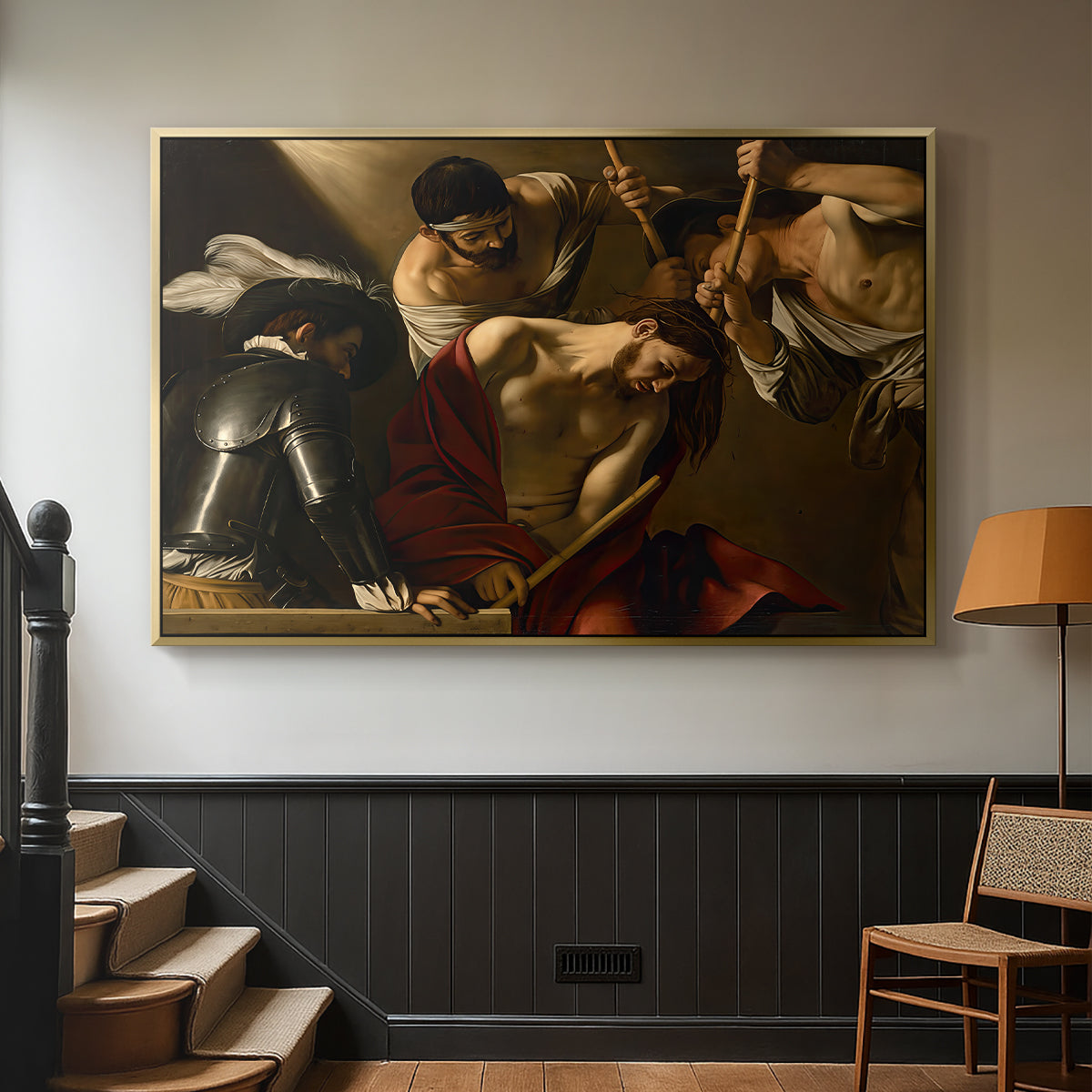 Gold floater framed canvas featuring an intense religious composition with strong shadow and physical struggle, displayed in a hallway near a staircase.