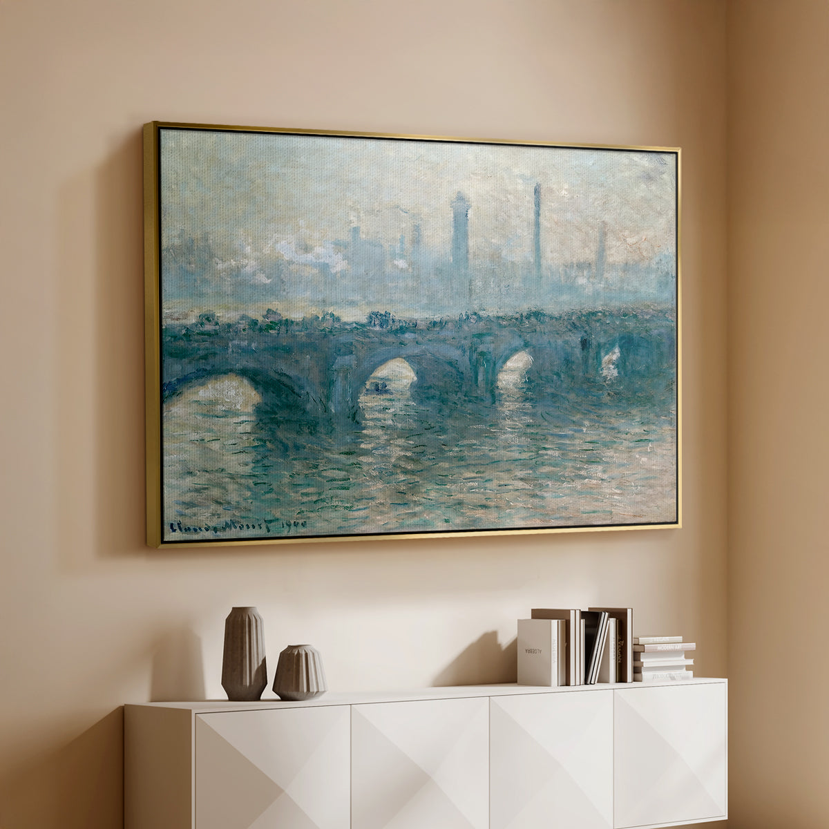 Gold floater framed canvas of Waterloo Bridge, Gray Weather, 1900 by Claude Monet, featuring an impressionist cityscape with bridge fading into fog over water above a console cabinet in a minimalist entryway.