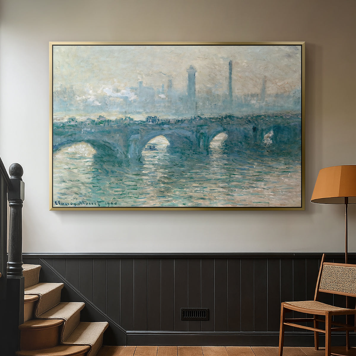 Gold floater framed canvas featuring an atmospheric urban landscape with misty light and reflections, displayed in a hallway near a staircase.