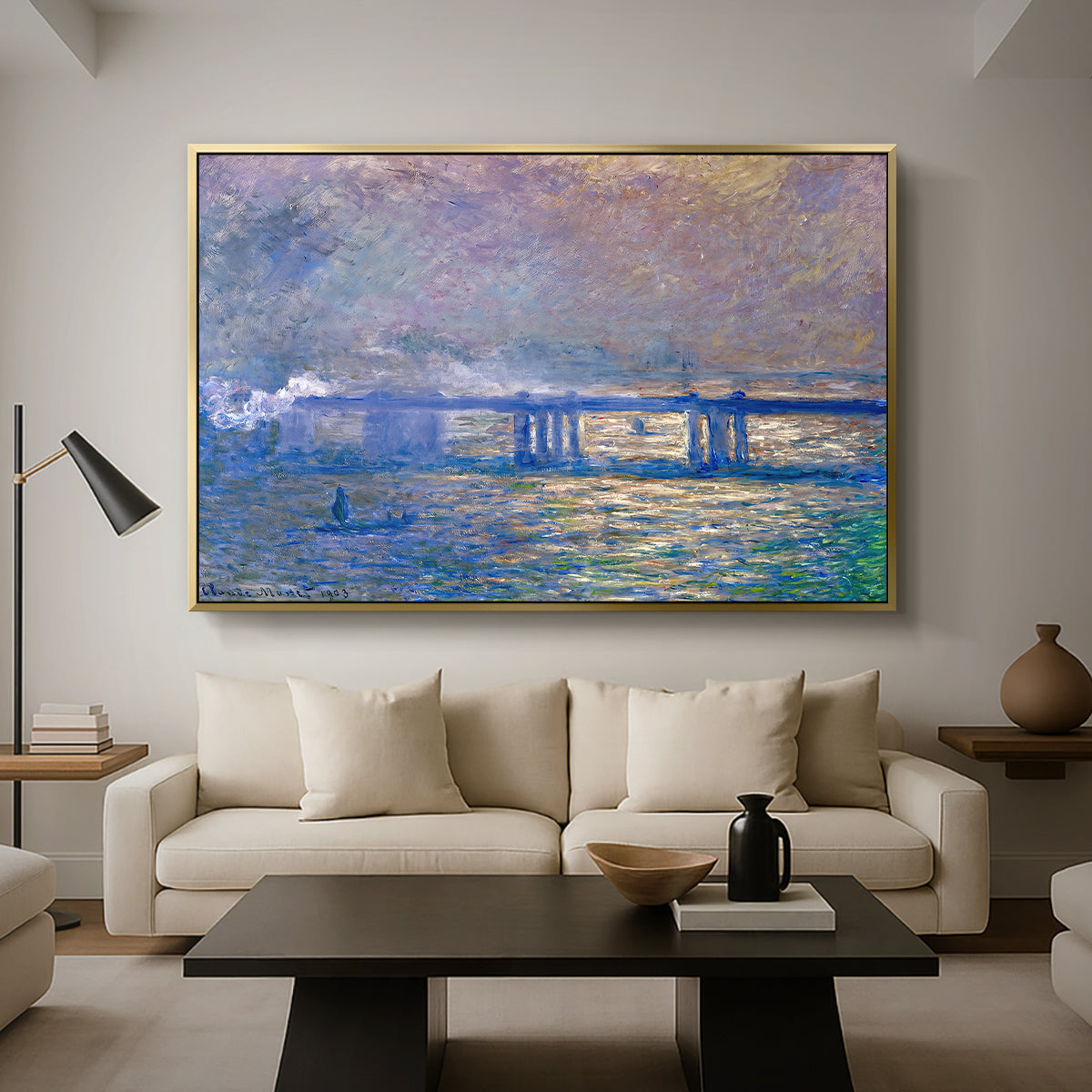 Charing Cross Bridge, 1903 by Claude Monet as a gold floater framed canvas featuring an impressionist view of bridge stretching across river with soft light and haze, displayed above a sofa in a modern living room.