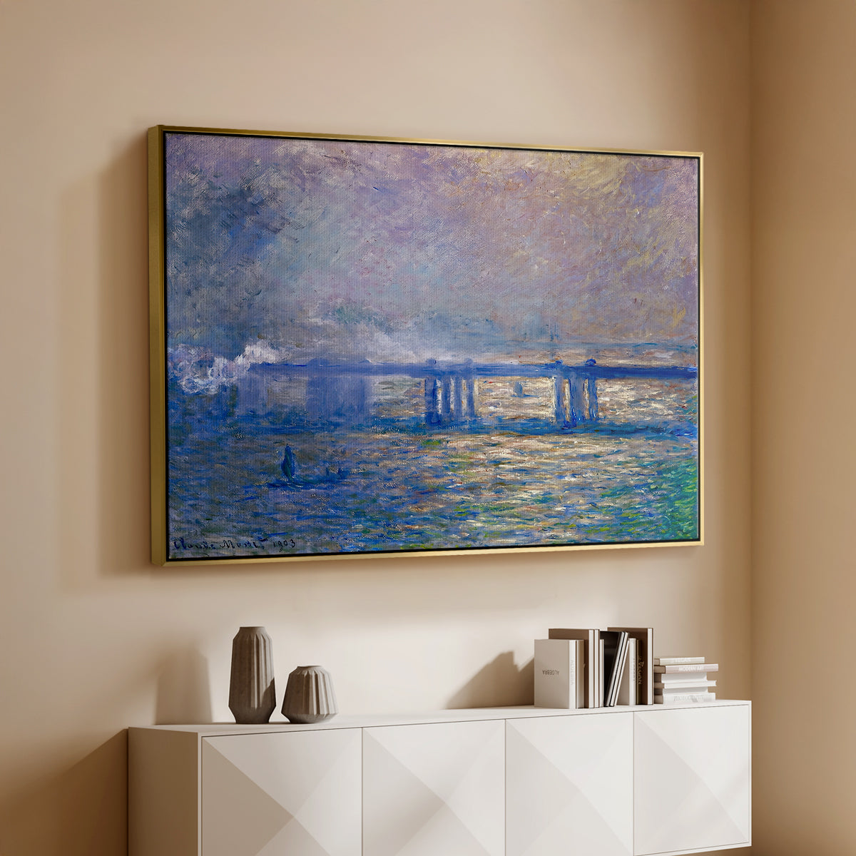 Gold floater framed canvas of Charing Cross Bridge, 1903 by Claude Monet, featuring an urban landscape with bridge and water rendered in blurred tones above a console cabinet in a minimalist entryway.