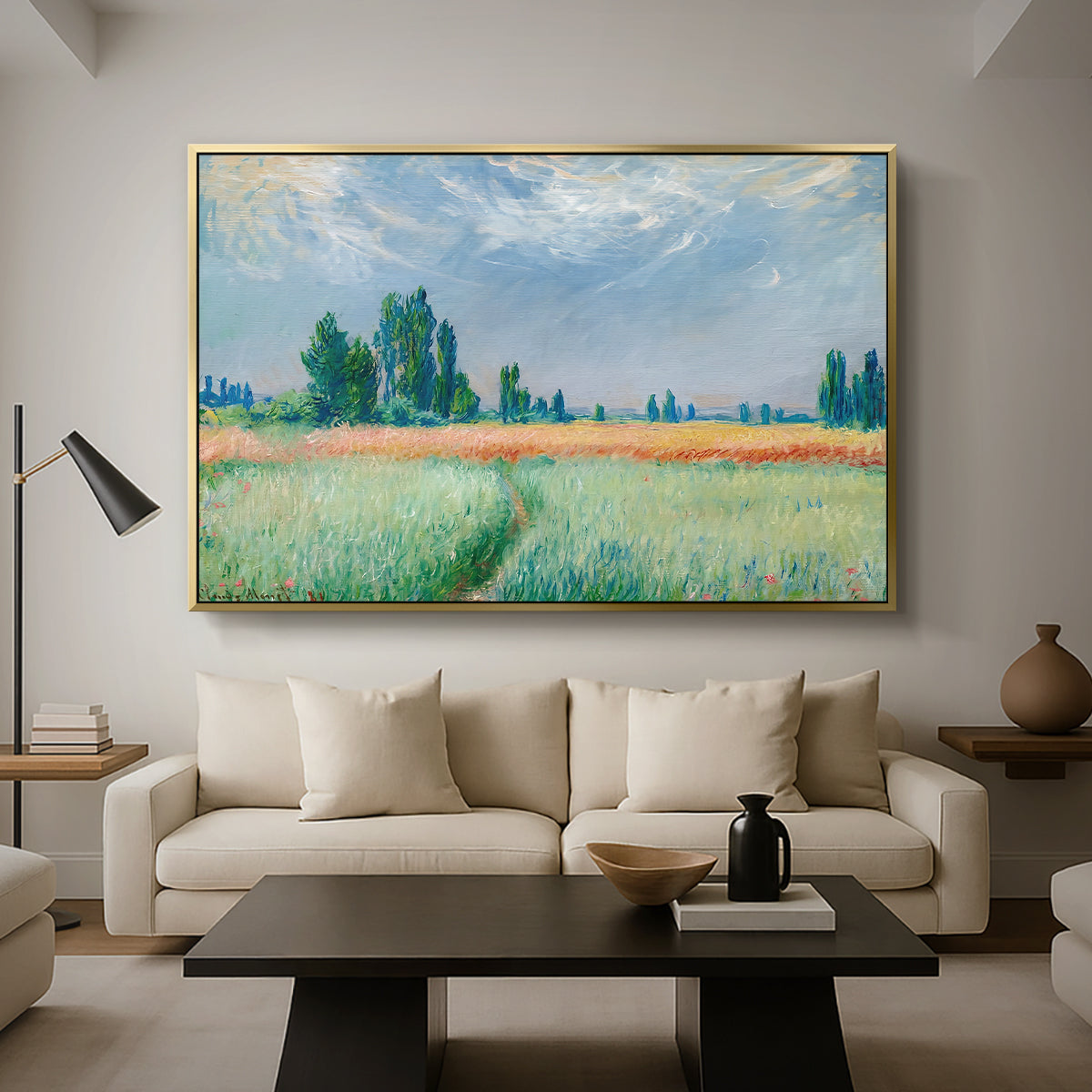 The Wheat Field (Champ de Blé), 1881 by Claude Monet as a gold floater framed canvas featuring a golden wheat field stretching across landscape under soft sky, displayed above a sofa in a modern living room.