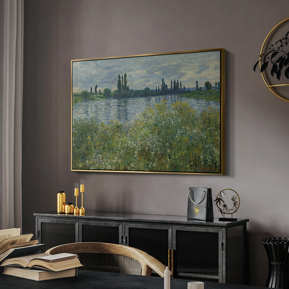 Banks of the Seine, Vétheuil, 1880 by Claude Monet in a gold floater framed canvas featuring a tranquil riverside scene with houses and vegetation, displayed above a desk in a dark home office interior.