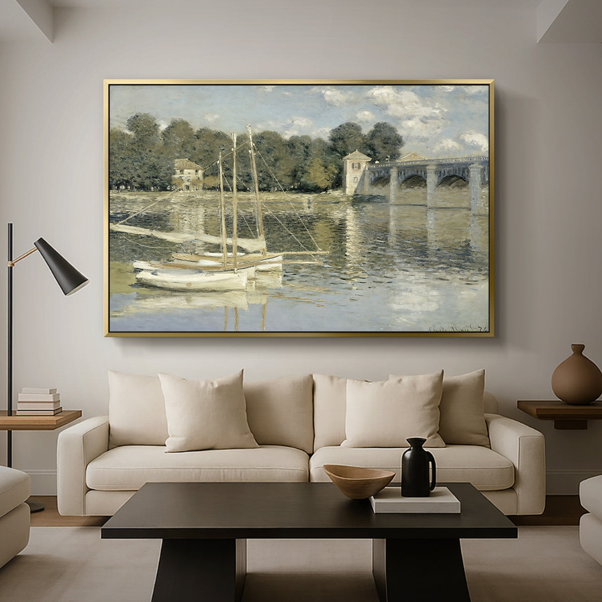 The Bridge at Argenteuil, 1874 by Claude Monet as a gold floater framed canvas featuring a bridge spanning river with sailboats and reflections in water, displayed above a sofa in a modern living room.