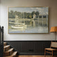 Gold floater framed canvas featuring a riverside view with architecture and nautical activity, displayed in a hallway near a staircase.