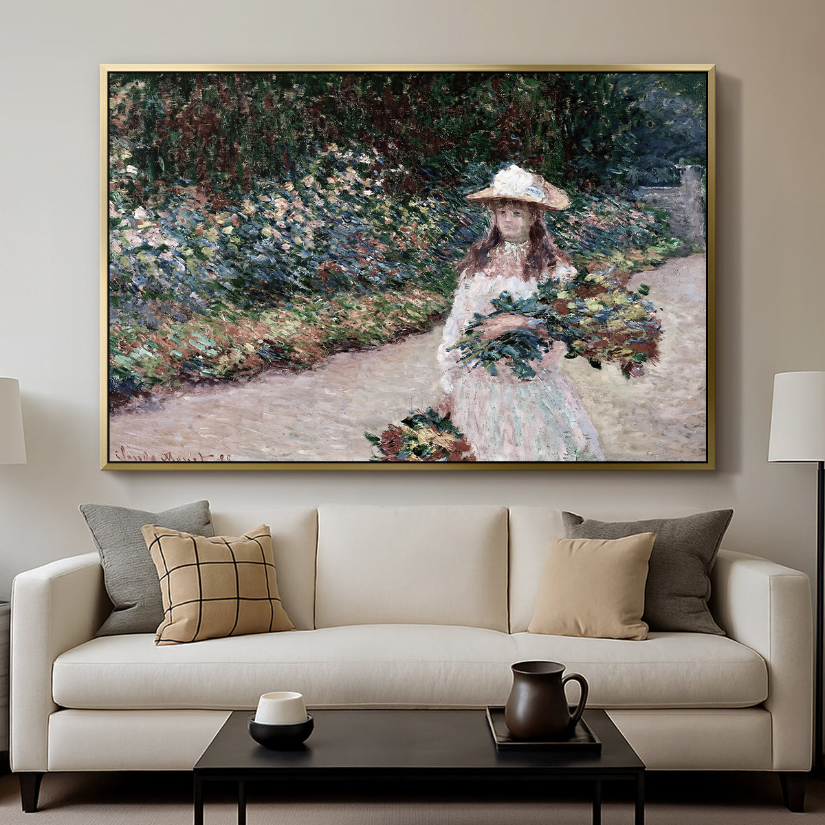 Young Girl in the Garden at Giverny, 1888 by Claude Monet displayed in a gold floater framed canvas above a sofa in a clean living room.
