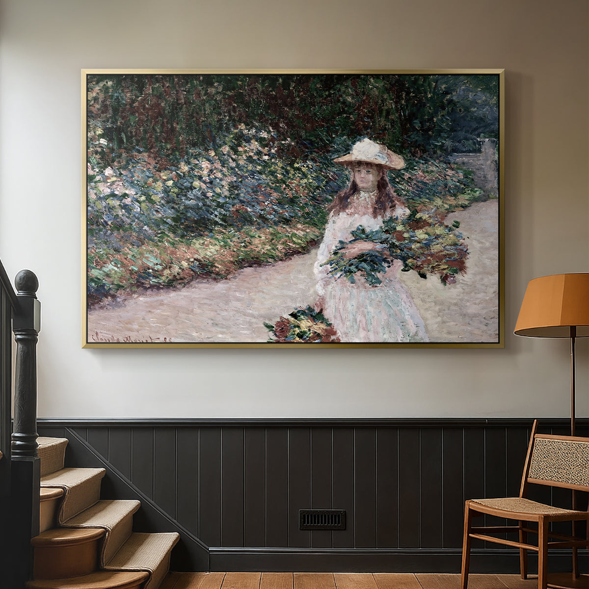 Gold floater framed canvas featuring a tranquil outdoor portrait of girl in floral setting, displayed in a hallway near a staircase.