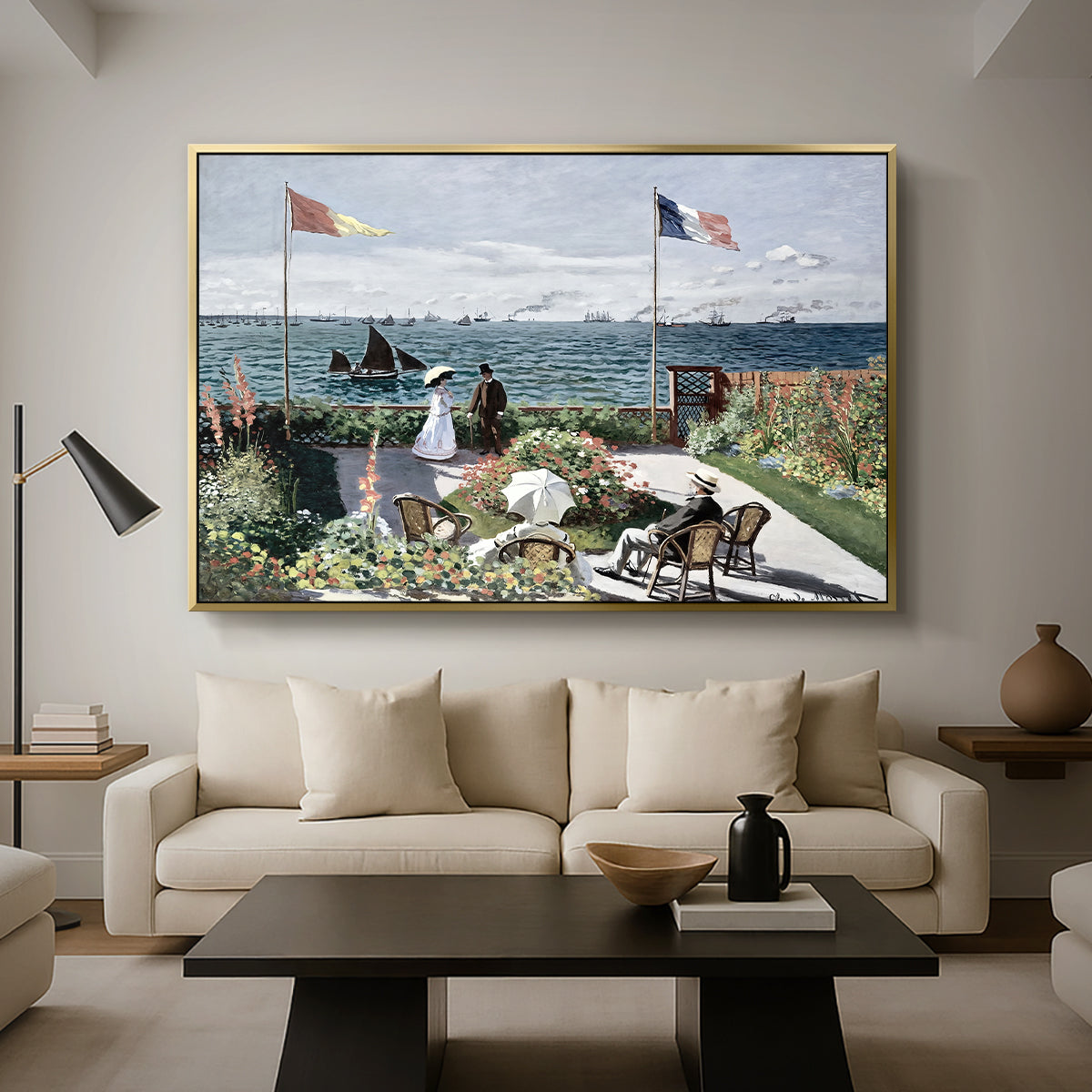Garden at Sainte-Adresse, 1867 by Claude Monet as a gold floater framed canvas featuring a seaside garden with flowers, flags, and figures overlooking the water, displayed above a sofa in a modern living room.