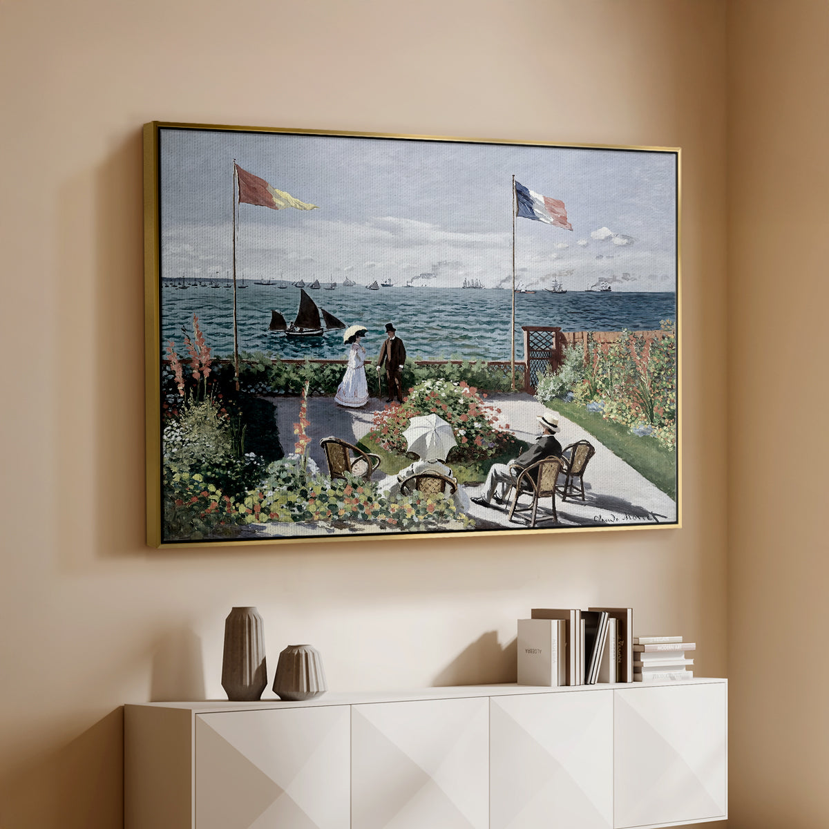 Gold floater framed canvas of Garden at Sainte-Adresse, 1867 by Claude Monet, featuring an impressionist coastal garden with people and ocean view above a console cabinet in a minimalist entryway.