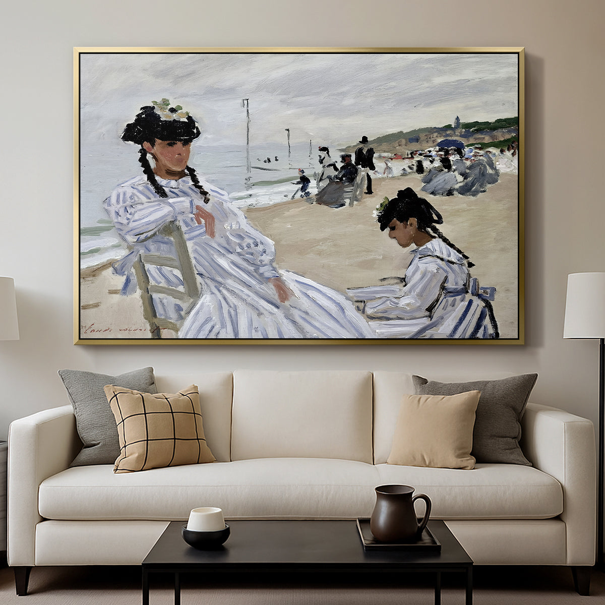 On the Beach at Trouville, 1870 by Claude Monet displayed in a gold floater framed canvas above a sofa in a clean living room.