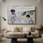 On the Beach at Trouville, 1870 by Claude Monet as a gold floater framed canvas featuring figures seated on beach with parasols facing the ocean, displayed above a sofa in a modern living room.
