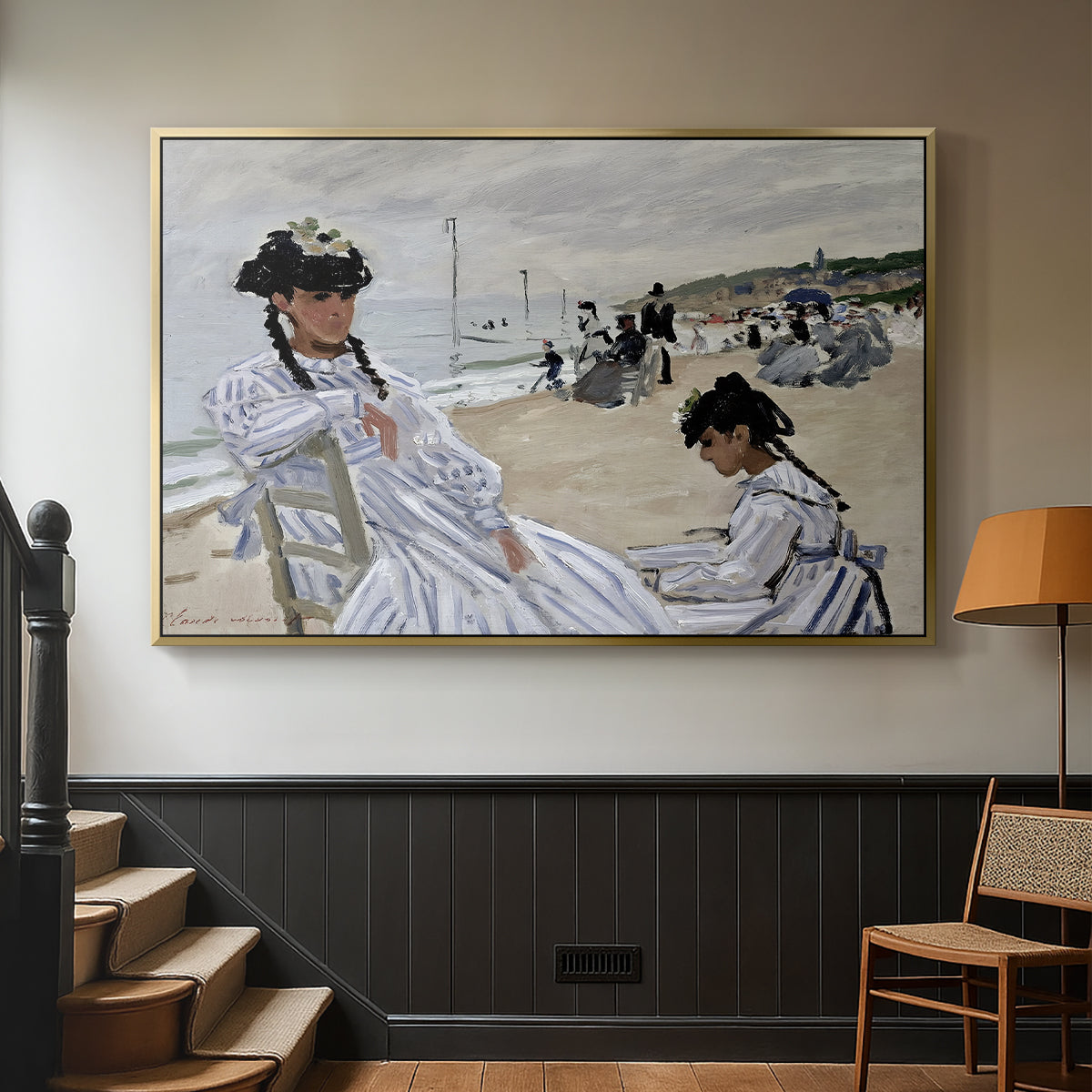 Gold floater framed canvas featuring a coastal leisure scene with figures looking out to sea, displayed in a hallway near a staircase.