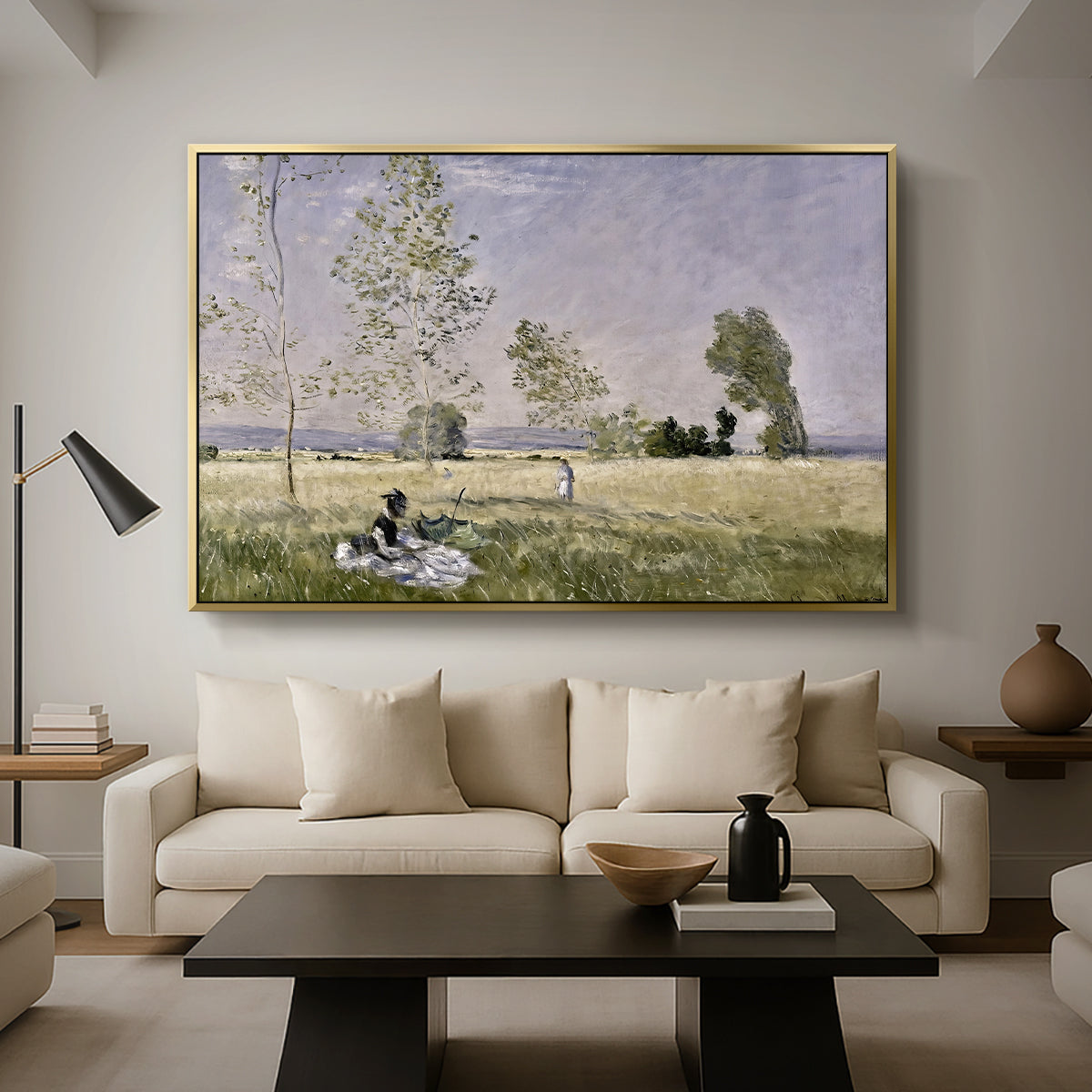 Summer (L'ete), 1874 by Claude Monet as a gold floater framed canvas featuring a woman seated in grassy field beneath tree in bright summer landscape, displayed above a sofa in a modern living room.