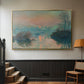 Gold floater framed canvas featuring an atmospheric landscape combining cold tones and warm sky, displayed in a hallway near a staircase.