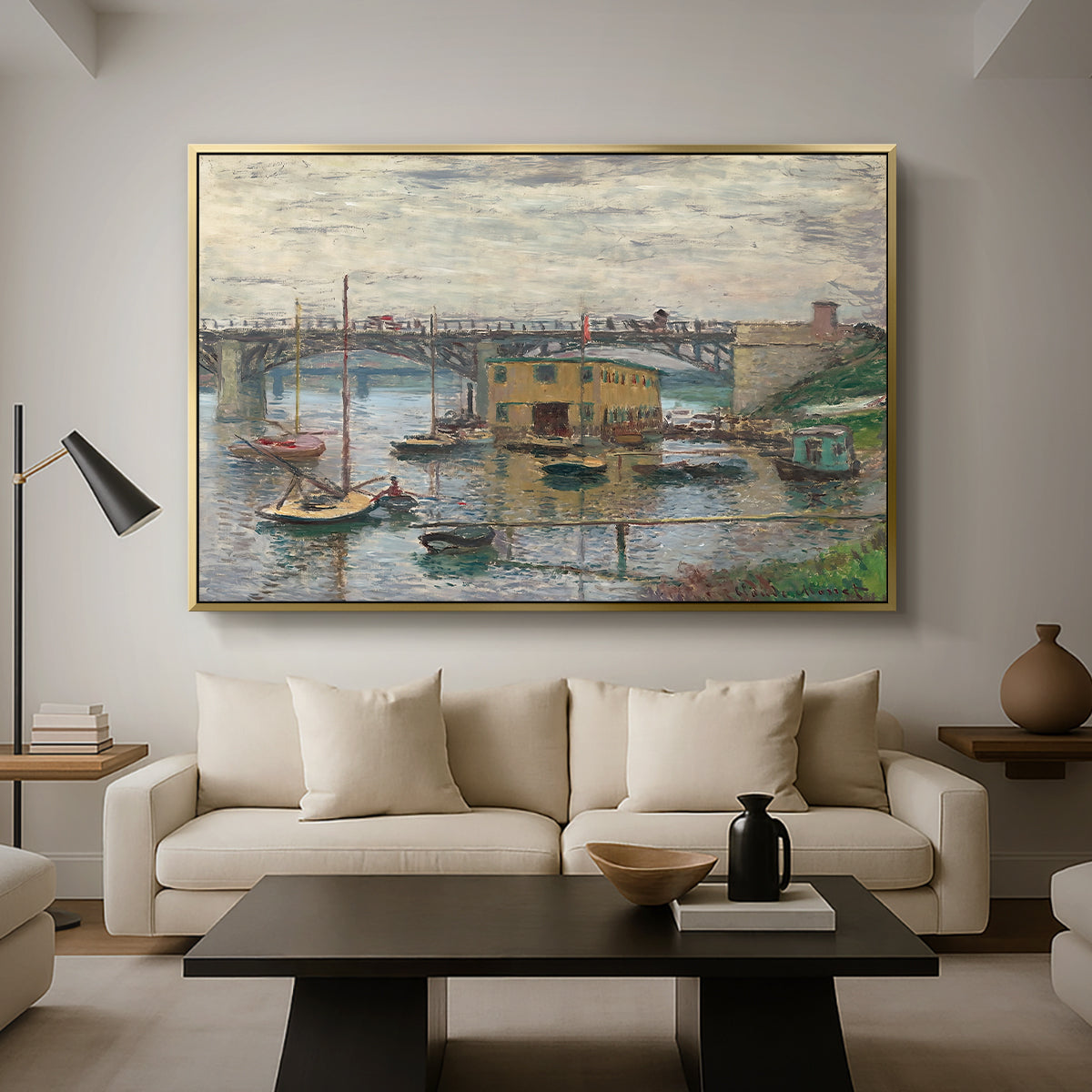 Bridge at Argenteuil on a Gray Day, c. 1876 by Claude Monet as a gold floater framed canvas featuring a bridge crossing river under gray sky with muted reflections, displayed above a sofa in a modern living room.