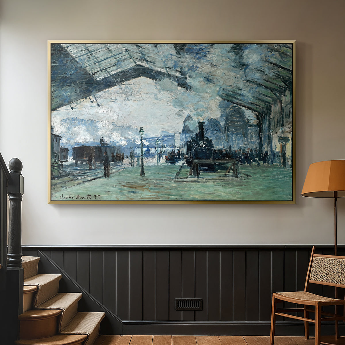 Gold floater framed canvas featuring a dramatic depiction of industrial space with trains and light, displayed in a hallway near a staircase.