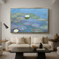 Water Lilies (Nymphéas), 1897-1899 by Claude Monet as a gold floater framed canvas featuring floating water lilies on pond with reflections of sky and foliage, displayed above a sofa in a modern living room.