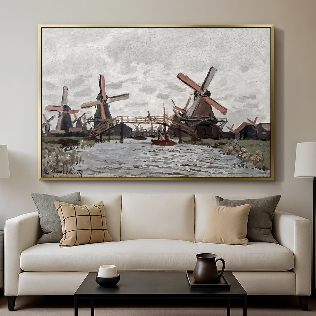 Windmills near Zaandam, 1871 by Claude Monet displayed in a gold floater framed canvas above a sofa in a clean living room.