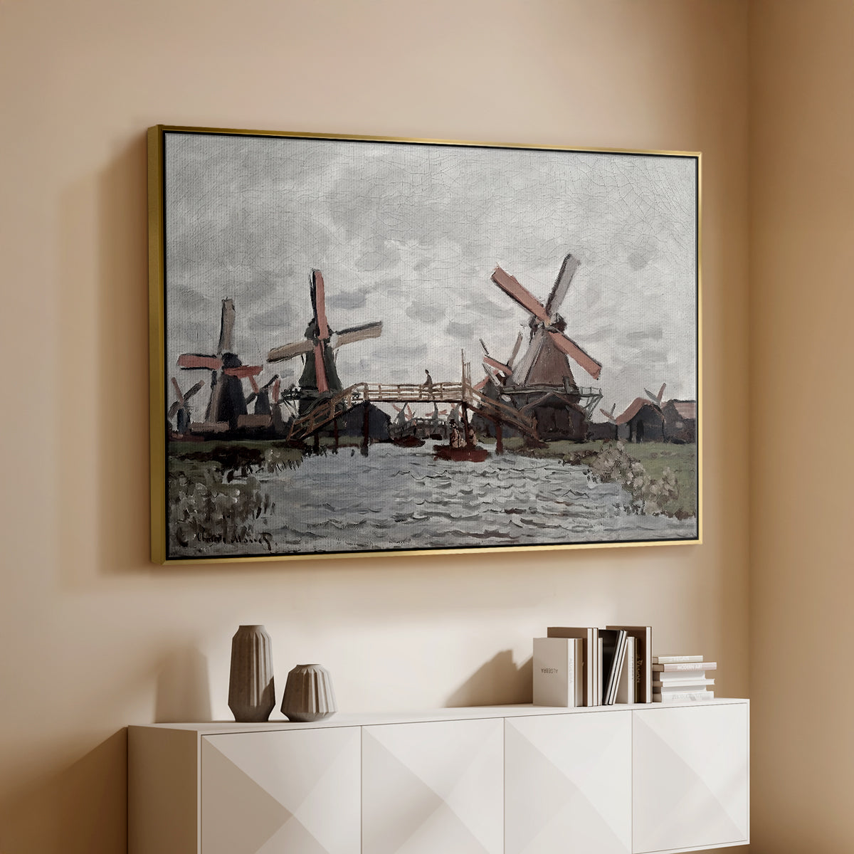 Gold floater framed canvas of Windmills near Zaandam, 1871 by Claude Monet, featuring an impressionist view of Dutch windmills along riverbank above a console cabinet in a minimalist entryway.