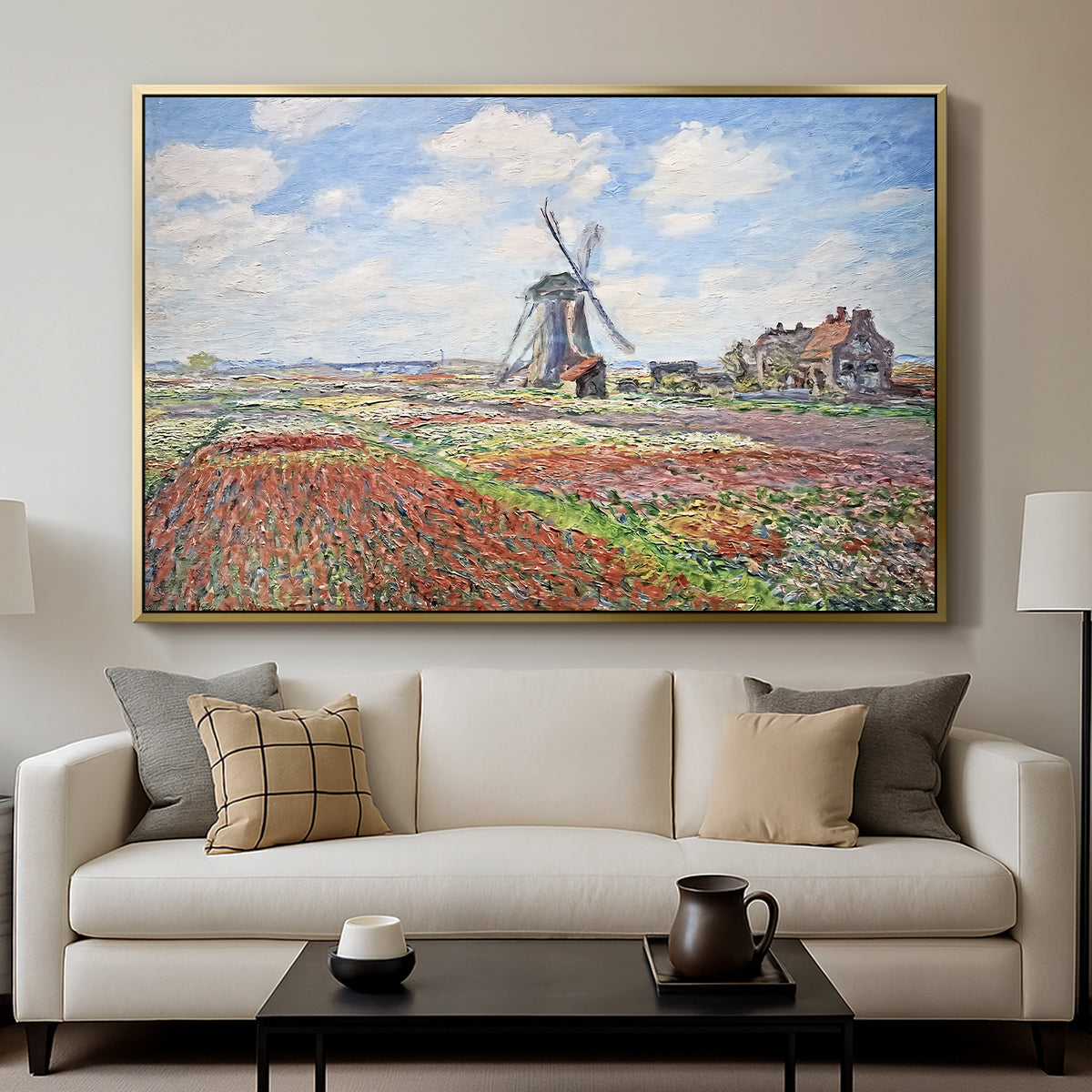 Tulip Fields with the Rijnsburg Windmill, 1886 by Claude Monet displayed in a gold floater framed canvas above a sofa in a clean living room.