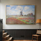 Gold floater framed canvas featuring a rural scene with patterned rows of flowers and windmill, displayed in a hallway near a staircase.