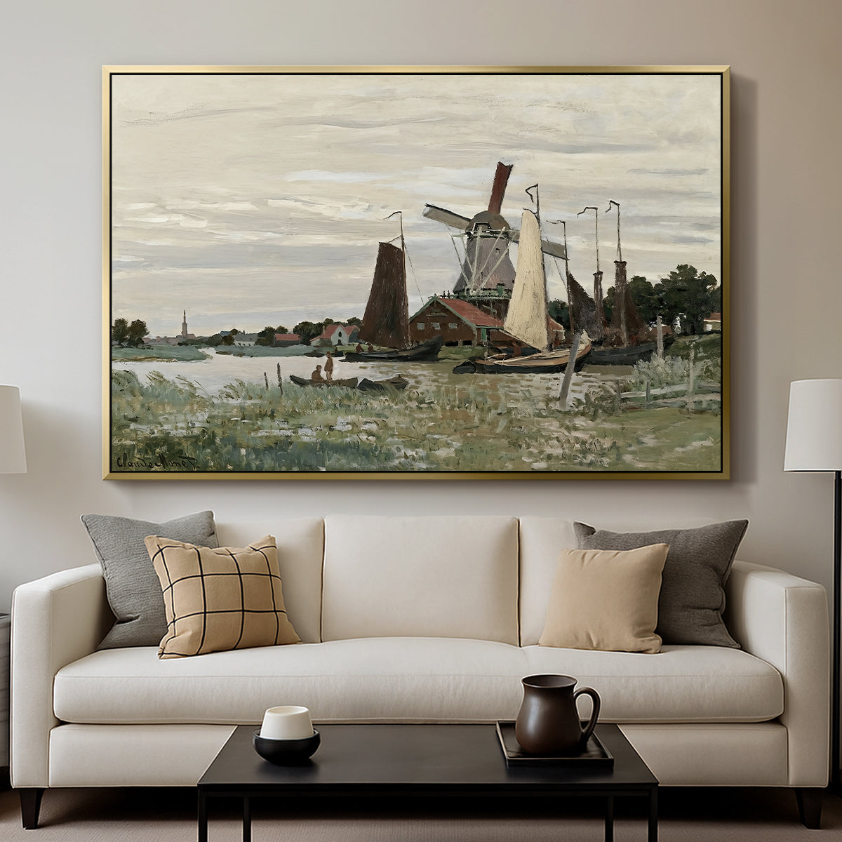 Windmill at Zaandam, 1871 by Claude Monet displayed in a gold floater framed canvas above a sofa in a clean living room.