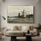 Windmill at Zaandam, 1871 by Claude Monet as a gold floater framed canvas featuring a single windmill beside water with surrounding buildings and sky, displayed above a sofa in a modern living room.