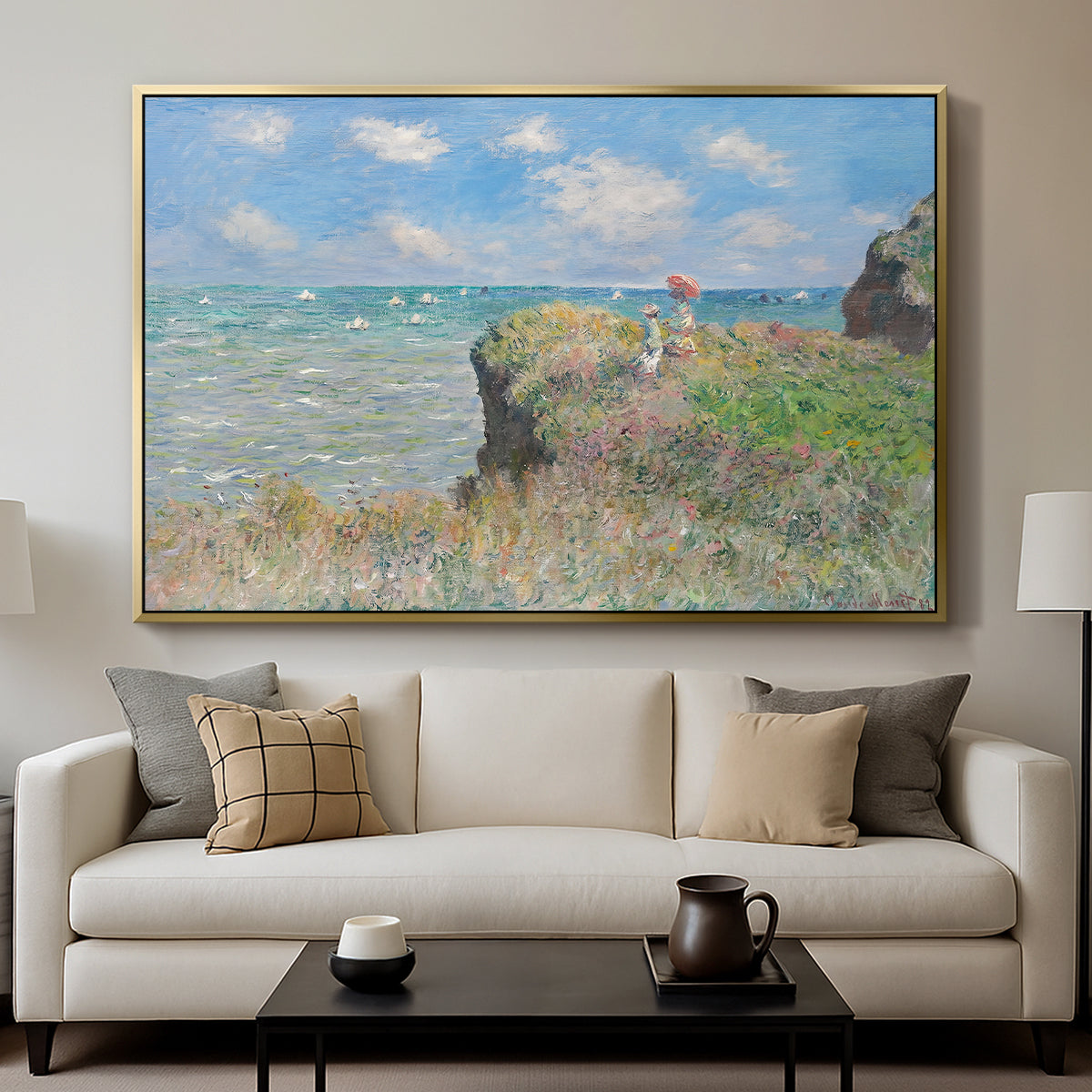 The Cliff Walk at Pourville, 1882 by Claude Monet displayed in a gold floater framed canvas above a sofa in a clean living room.