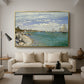 Regatta at Sainte-Adresse, 1867 by Claude Monet as a gold floater framed canvas featuring sailboats gathered near shore with flags and spectators along coastline, displayed above a sofa in a modern living room.