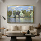 Houses on the Zaan River at Zaandam, 1871 by Claude Monet as a gold floater framed canvas featuring a row of houses along river with reflections in calm water, displayed above a sofa in a modern living room.