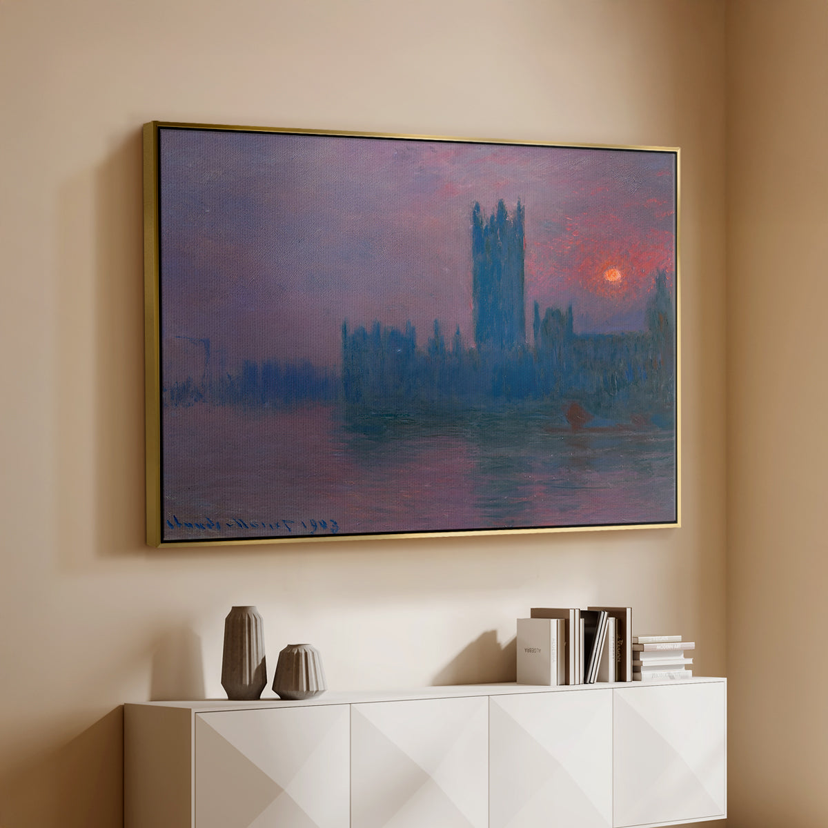 Gold floater framed canvas of The Houses of Parliament, Sunset, 1903 by Claude Monet, featuring an impressionist cityscape with warm sunset light over water above a console cabinet in a minimalist entryway.