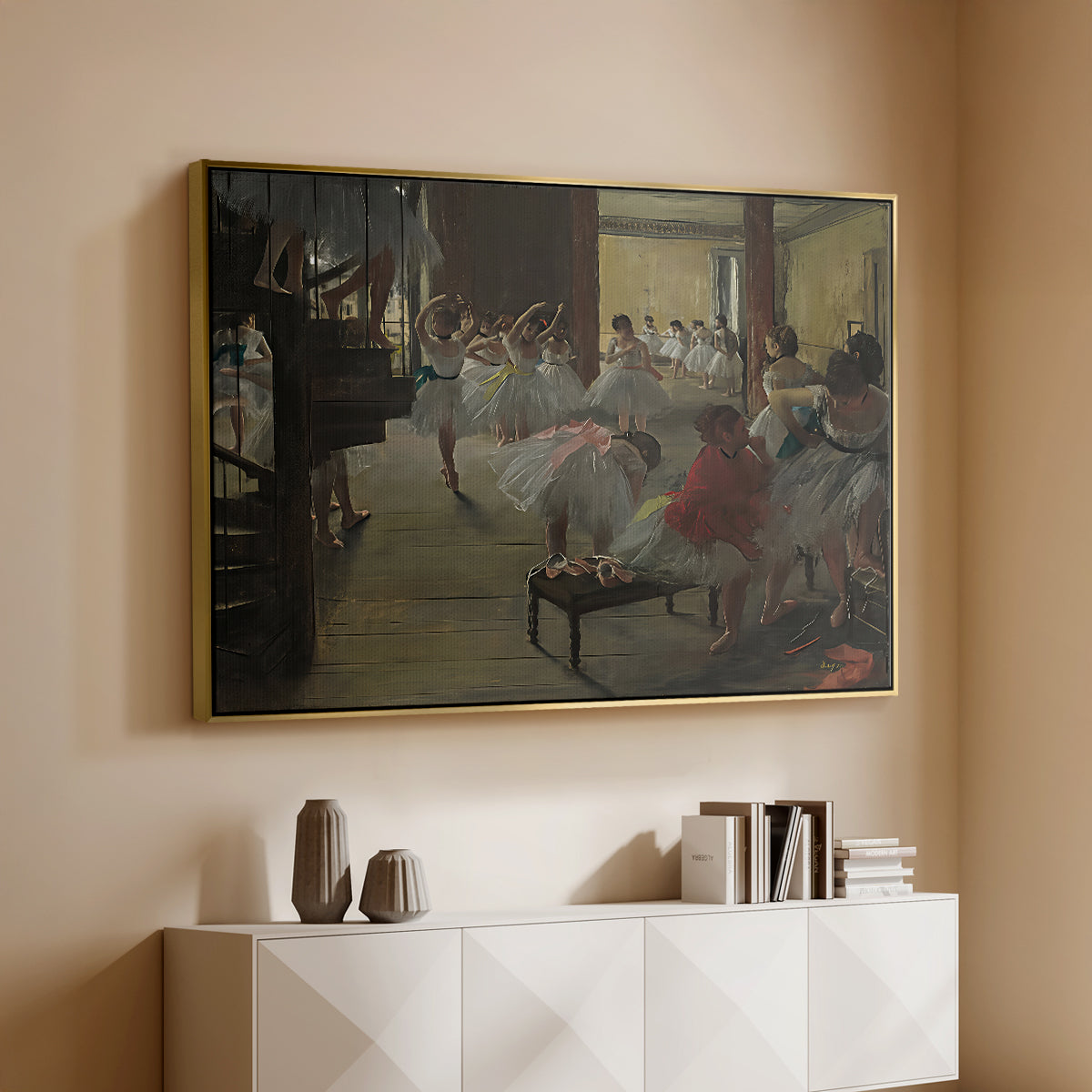 Gold floater framed canvas of The Dance Class, c. 1873 by Edgar Degas, featuring a rehearsal scene with dancers stretching and posing indoors above a console cabinet in a minimalist entryway.
