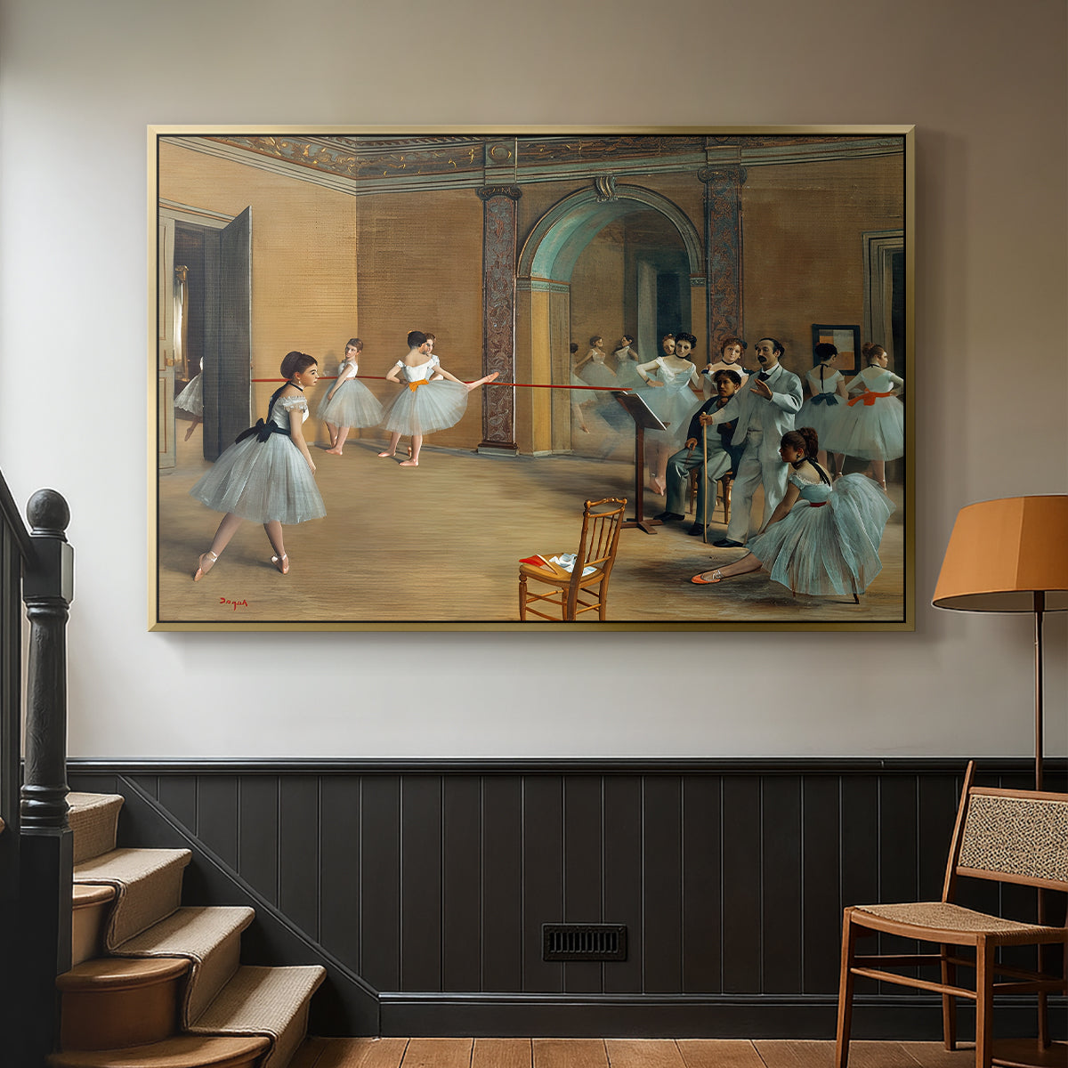 Gold floater framed canvas featuring an elegant rehearsal space with dancers in soft lighting, displayed in a hallway near a staircase.