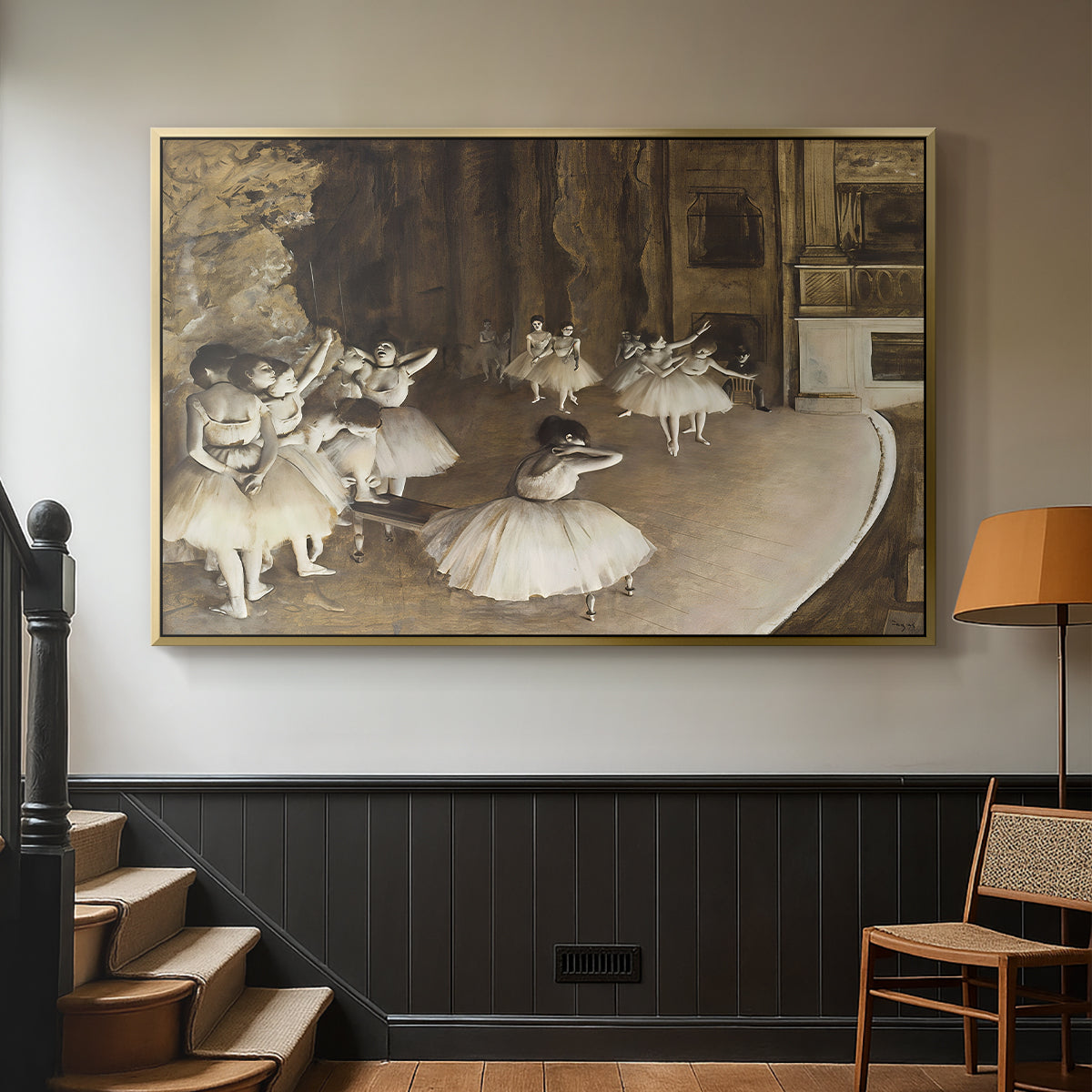 Gold floater framed canvas featuring dancers arranged on stage with visible set and depth, displayed in a hallway near a staircase.