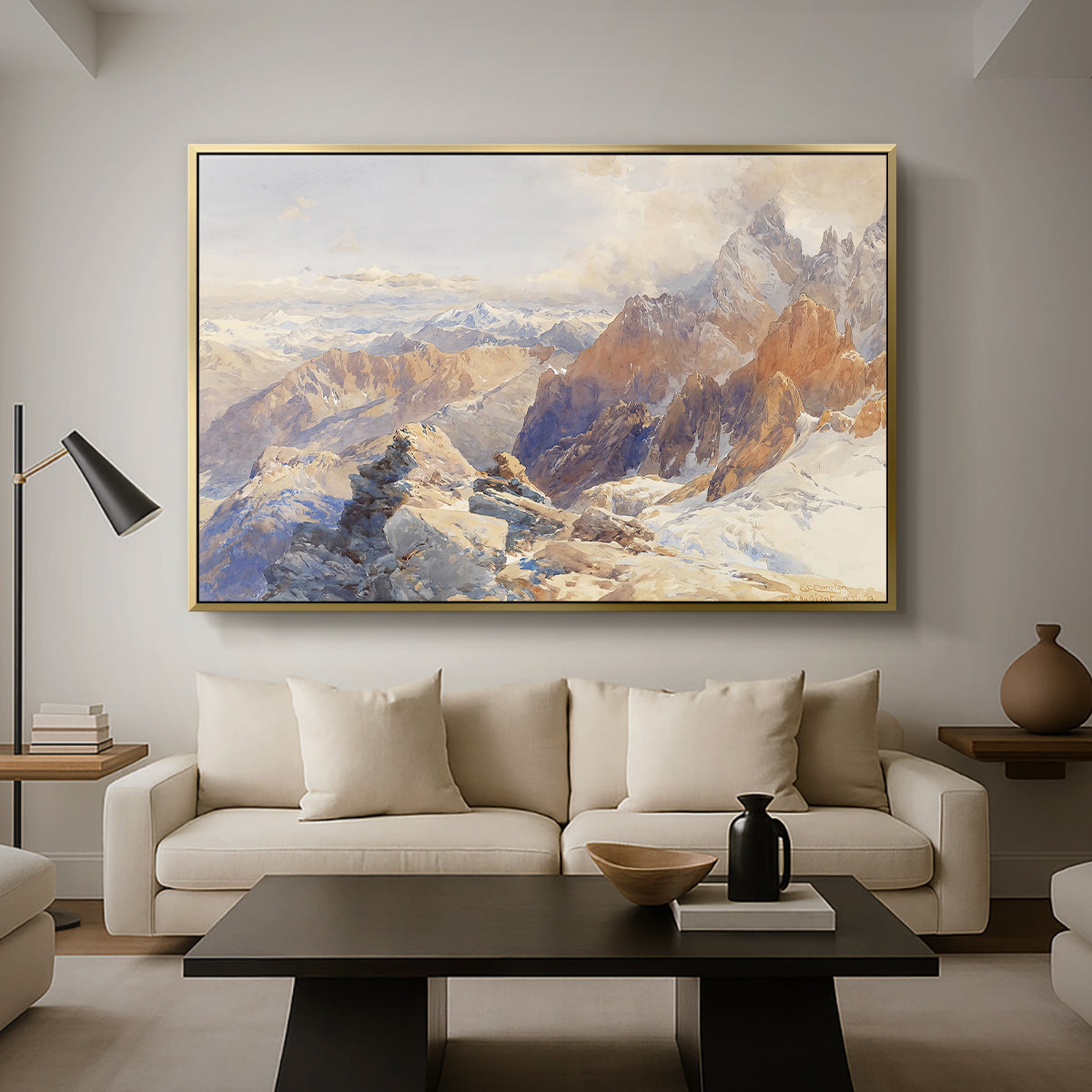 Col du Géant, 1903 by Edward Theodore Compton as a gold floater framed canvas featuring a mountain pass with snow-covered peaks and expansive alpine valley, displayed above a sofa in a modern living room.