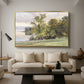 Landscape at Lake Starnberg, 1890 by Edward Theodore Compton as a gold floater framed canvas featuring a lakeside landscape with calm water and trees along shoreline, displayed above a sofa in a modern living room.